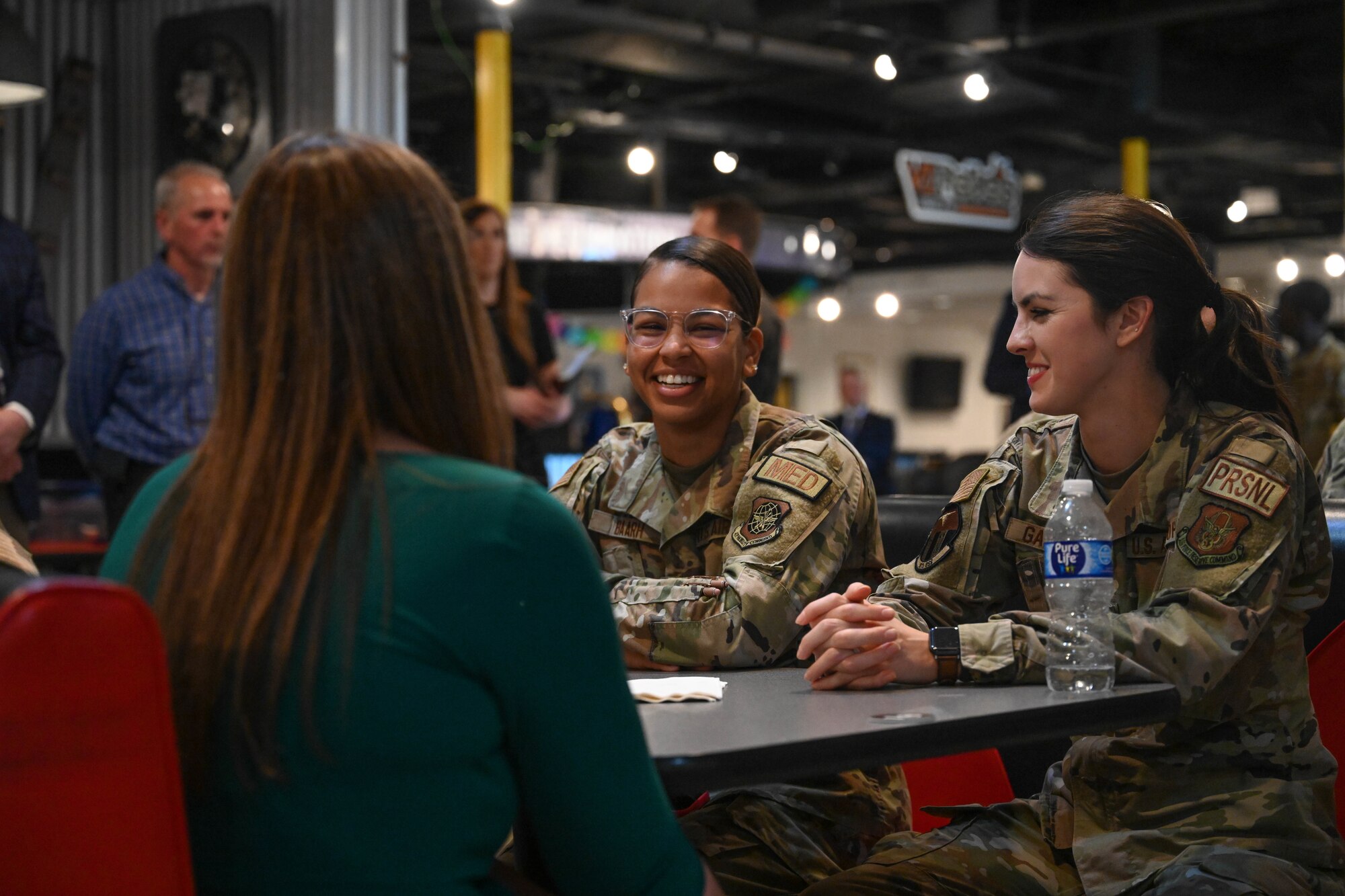 A woman in uniform sits at a table.