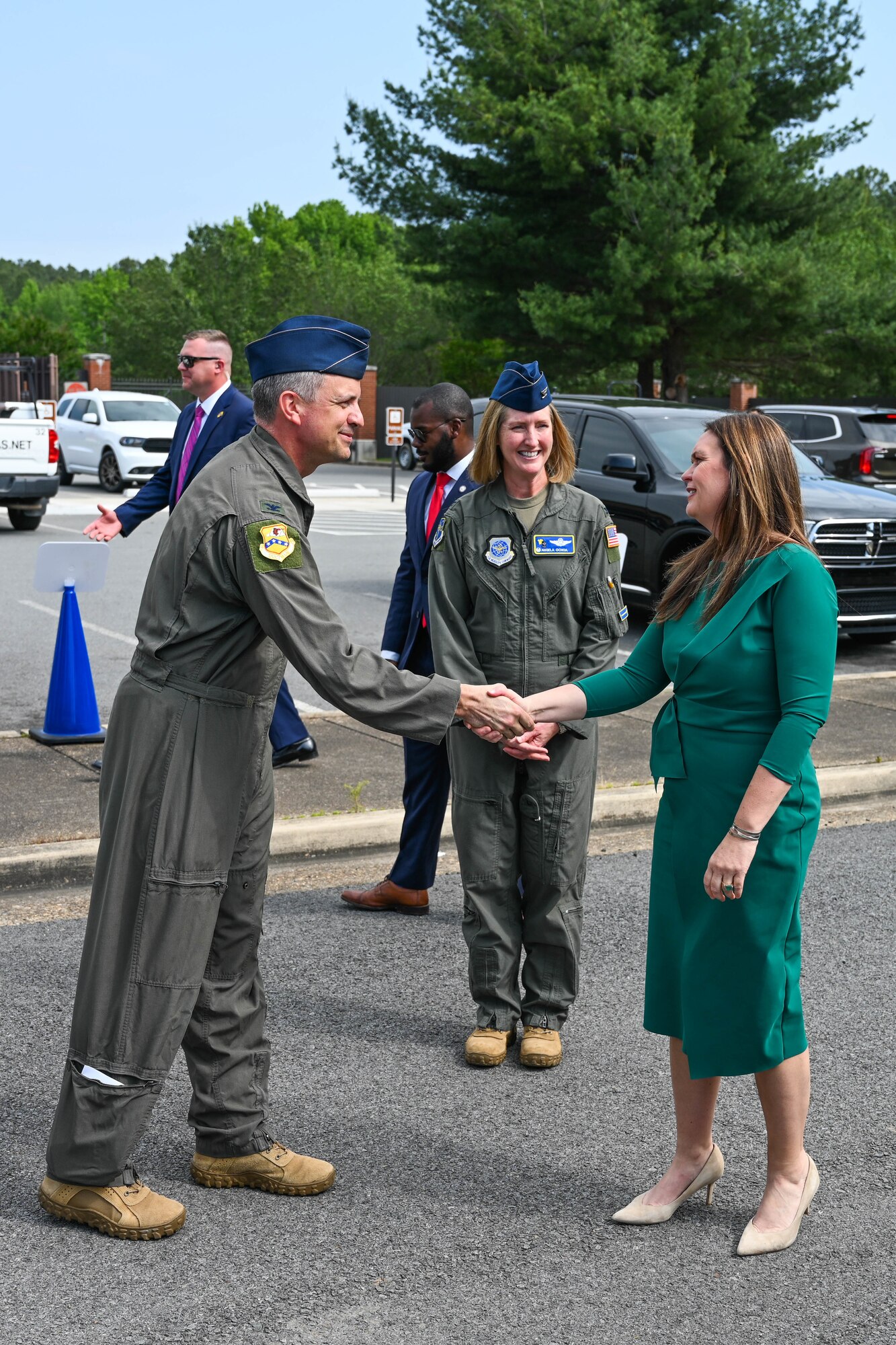 A man in uniform shakes a woman's hand.
