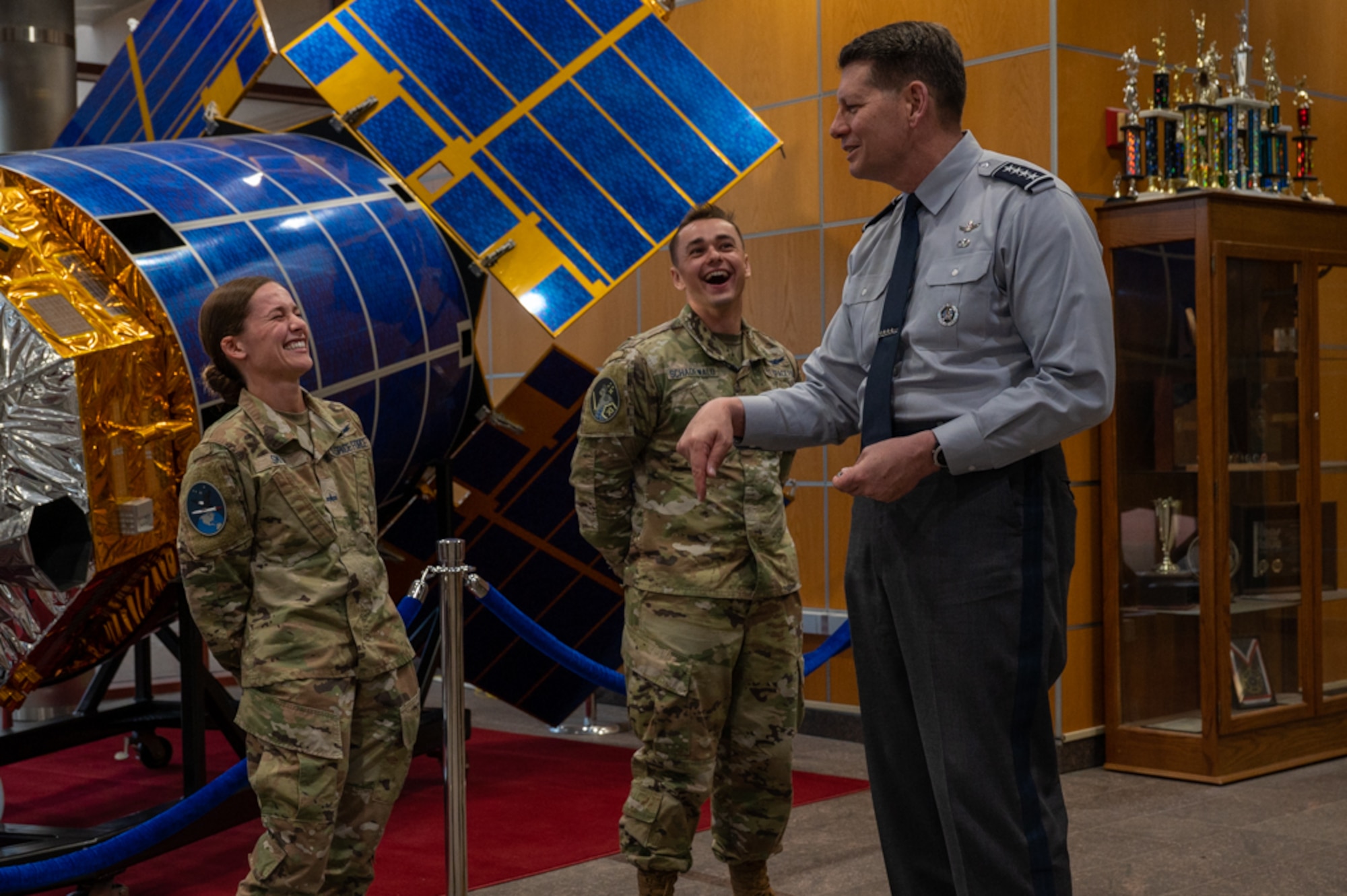 VCSO laughs and jokes with guardians in front of a model satellite.