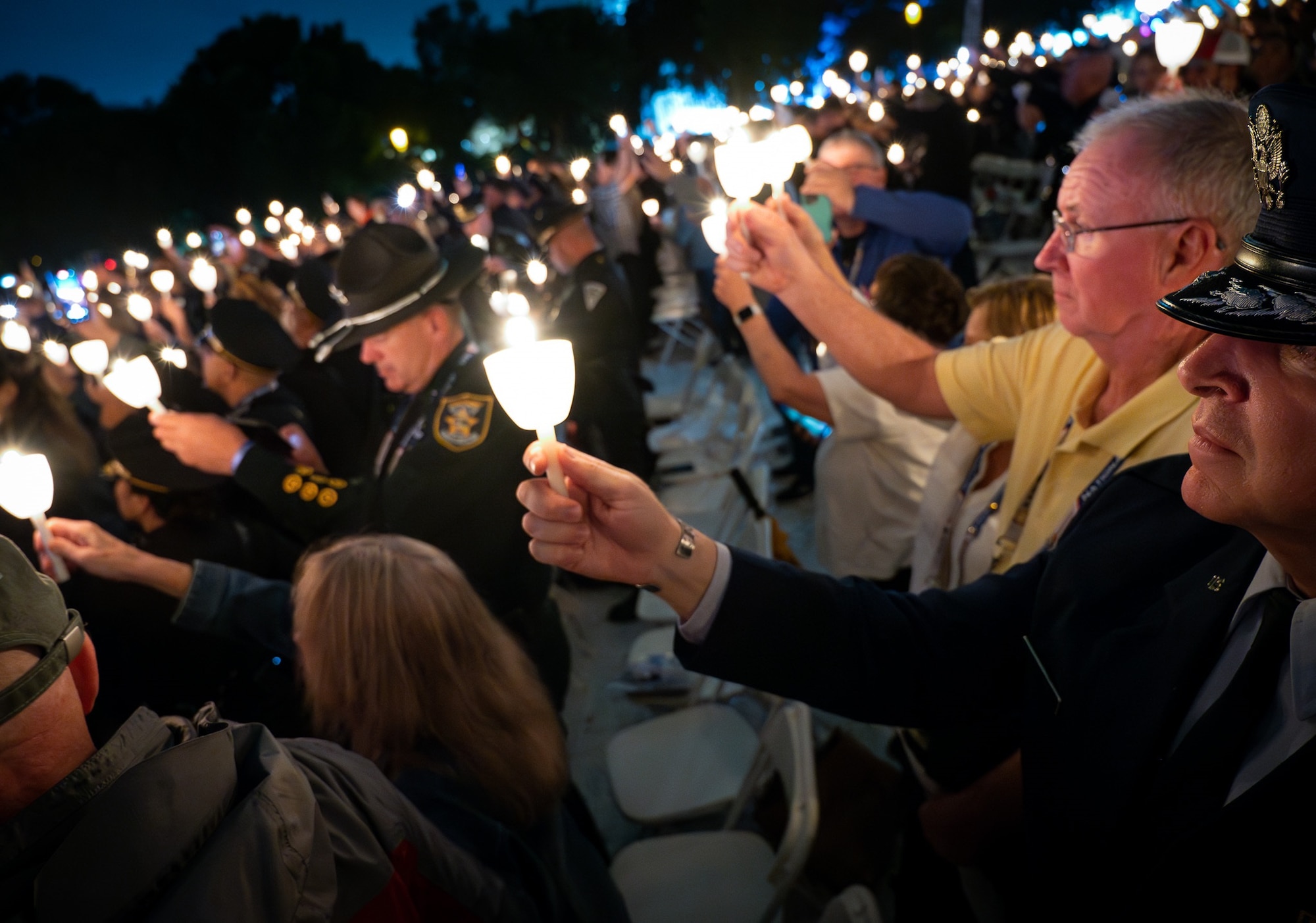 Brig. Gen. Terry Bullard, OSI commander, right, holds a candle during the 35th Annual Candlelight Vigil, May 13, as part of several events during National Police Week 2023 in Washington, D.C. Hundreds of law enforcement officers and families gathered at the National Mall to honor police officers killed in the line of duty. Col. Eugene Smith, an OSI officer killed in a plane crash in 1952, was honored after being etched into the National Law Enforcement Officers Memorial this year. (U.S. Air Force Photo by Thomas Brading)
