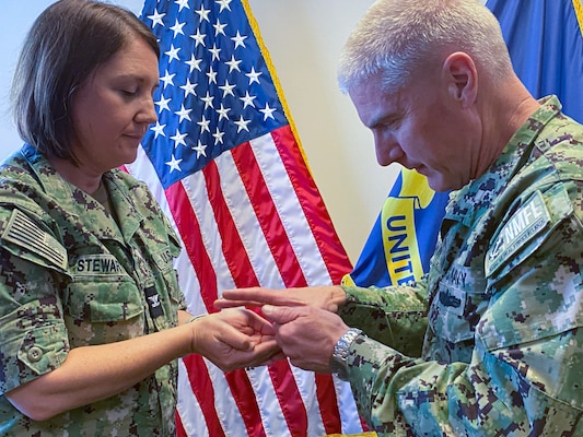 Capt. William Hlavin, the regional chaplain assigned to Naval Medical Forces Atlantic (NMFL), right, annoints Capt. Kathy Stewart, the director of meritime operations, left, during a blessing of the hands ceremony during National Nurses Week to NMFL nurses before they conduct their duties onboard Naval Support Activity (NSA) Hampton Roads - Portsmouth Annex.