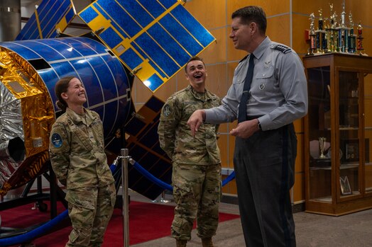  VCSO laughs and jokes with guardians in front of a model satellite.