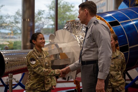 VCSO shakes hand with a guardian in front of a model satellite.