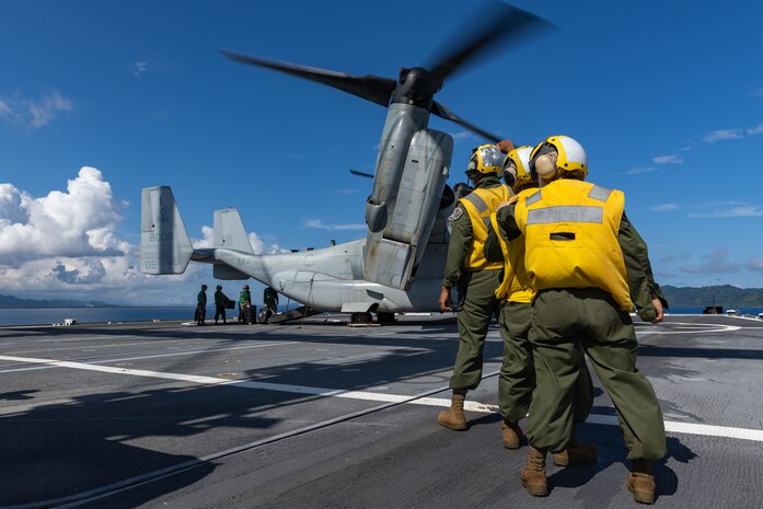 U.S. Marines, with Marine Aviation Logistics Squadron 16, 3rd Marine Aircraft Wing, signals to a MV-22B Osprey with Marine Medium Tiltrotor Squadron (VMM) 268, 1st MAW, aboard the SS Curtis (T-AVB-4) during Balikatan 23 off the coast of the Philippines, April 18, 2023. Balikatan 23 is the 38th iteration of the annual bilateral exercise between the Armed Forces of the Philippines and the U.S. military. The exercise includes three weeks of training focused on amphibious operations, command and control, humanitarian assistance, urban operations and counterterrorism skills throughout northern and western Luzon. Coastal defense training figures prominently in the Balikatan 23 training schedule.