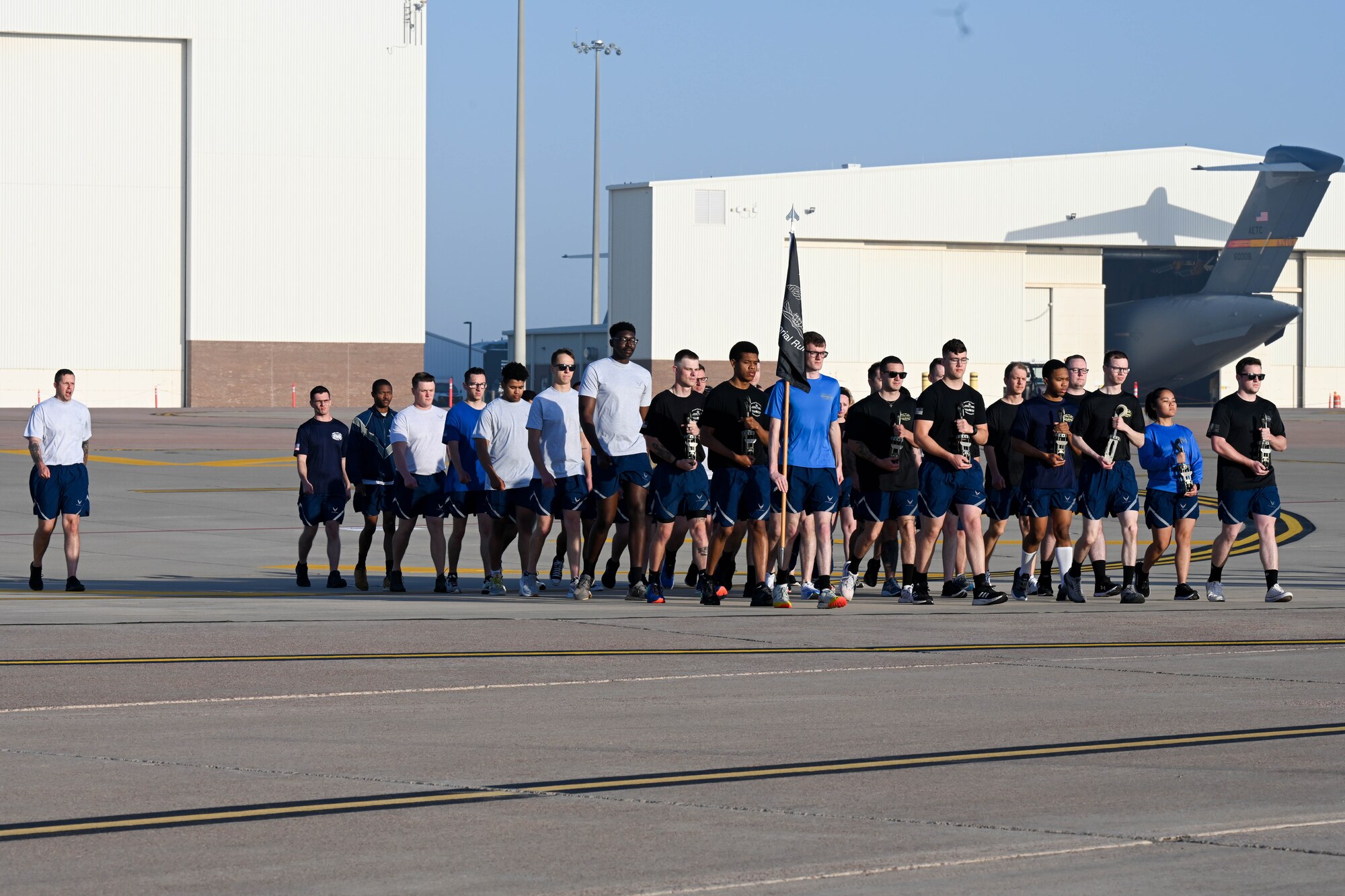 Airmen from the 97th Logistics Readiness Squadron (LRS) march on the flight line at Altus Air Force Base, Oklahoma, May 12, 2023. Before the run, the 97th LRS held a memorial ceremony honoring fallen “port dawgs.” (U.S. Air Force photo by Senior Airman Trenton Jancze)