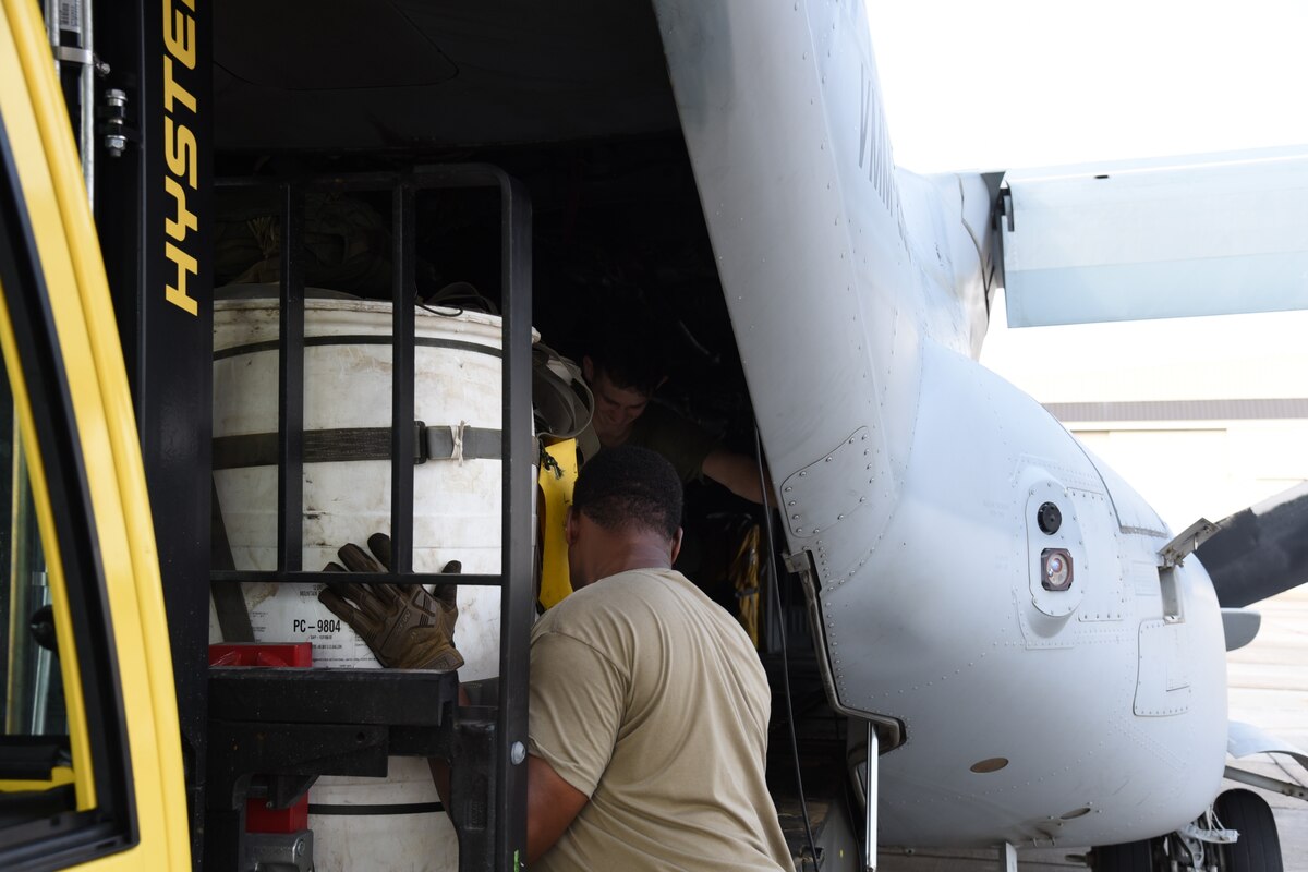 A Marine and an Airman work together to load a container delivery system on a MV-22B Osprey from the Marine Medium Tiltrotor Squadron (VMM) 263 to be dropped into the Camp Shelby drop zone.