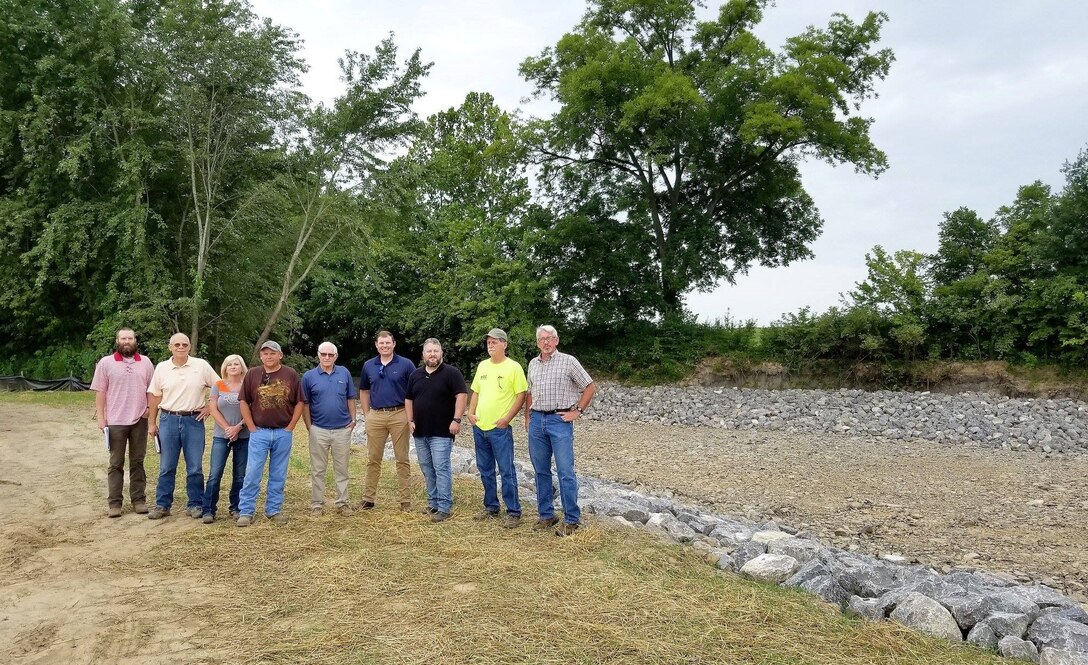 The Ramsey Creek Scour Repair project, which began on July 17, 2018, repaired a bank scour that threatened the integrity of the Little River Headwater Diversion Levee near Scott City, Missouri. 

Bank scour is the washing-away of bank soil and other materials by the force of natural water current. The Ramsey Creek bank scour could have potentially caused a breach in the Little River Headwater Diversion Levee, which is a flood control structure that protects nearby communities, lands, and infrastructure from flooding. The scour repair halted further bank erosion and potential damage to the levee, eliminating the threat of a levee breach and flooding.
The U.S. Army Corps of Engineers Memphis District managed the project in partnership with the Little River Drainage District as the project’s sponsor. The prime contractor, completing the work on the project, was D.W. Mertzke General Contractors along with sub-contractor Donald Bond Construction  .

Representatives from each of the organizations gathered at the project site on Aug.15 to conduct the final completed work inspection.

Pictured, from left to right, are Grayson Holt, Memphis District (project designer); Mark Games, D.W. Mertzke, (prime contractor); Chrissy Henderson, D.W. Mertzke; Mike Clark, Memphis District (project inspector); Donald Bond, Donald Bond Construction (sub-contractor); W. Dustin Boatwright, the Little River Drainage District’s executive vice president and chief engineer; Daimon McNew, the Memphis District’s Caruthersville Office area engineer; Mark Broughton, Donald Bond Construction; and Jack Ratliff, Memphis District (project lead civil engineer). Eric White, not pictured, was the Memphis District's operations project manager.