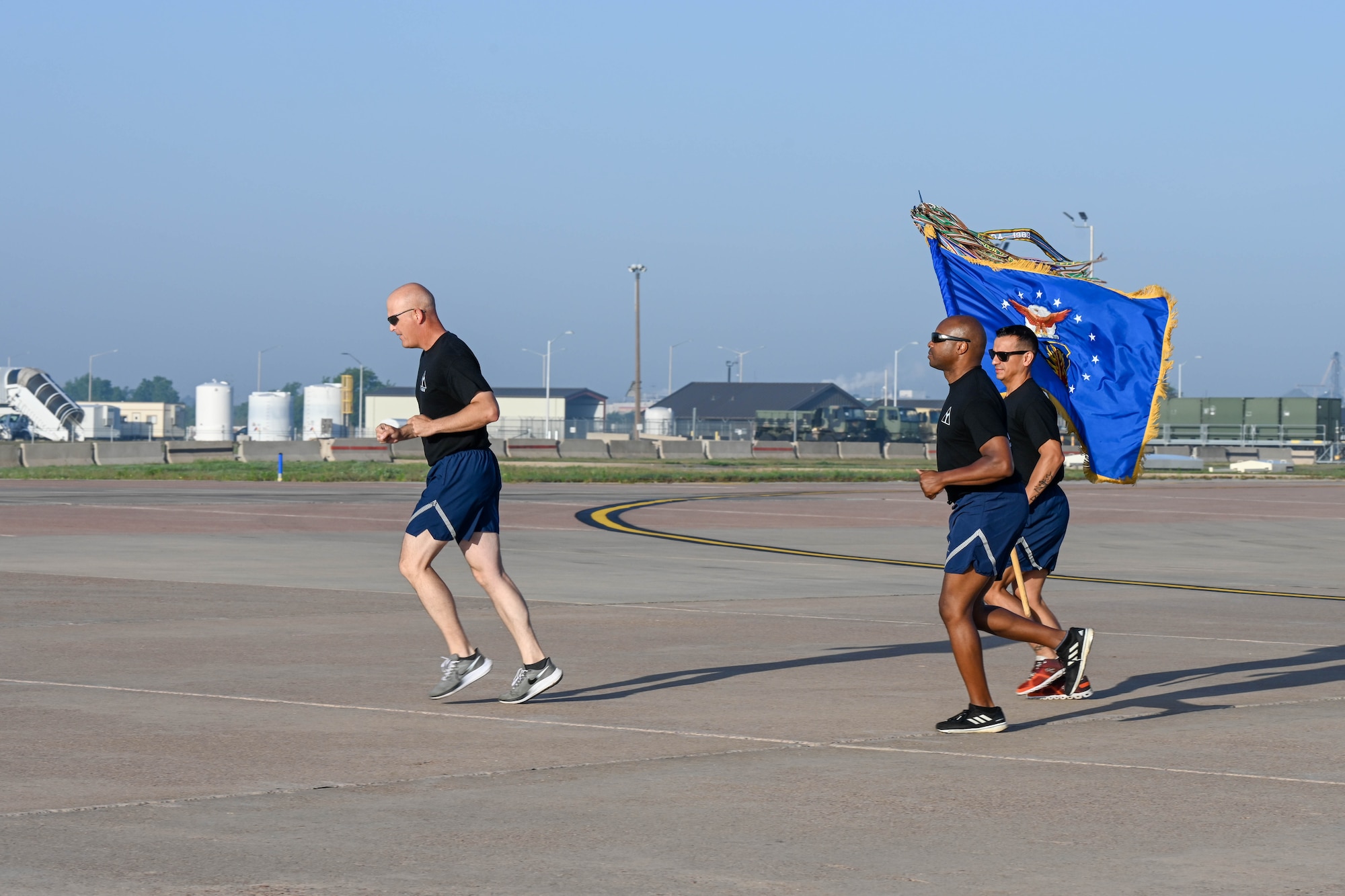 U.S. Air Force Col. Blaine Baker (left), 97th Air Mobility Wing (AMW), Col. Patrick Brady-Lee (center), 97th AMW vice commander, and Chief Master Sgt. Cesar Flores (right), 97th AMW command chief, run on the flight line at Altus Air Force Base, Oklahoma, May 12, 2023. Baker, Brady-Lee and Flores led Airmen from the 97th AMW during their 5K wing run around the flight line. (U.S. Air Force photo by Senior Airman Trenton Jancze)