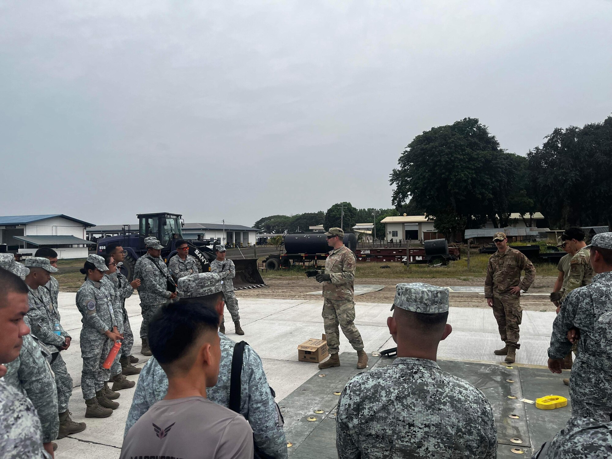 U.S. Air Force MSgt. Phillip Young, 18 Civil Engineer Group, briefs Philippine air force members with the 355th Aviation Engineer Wing on how to assemble a fiber-reinforced polymer mat during a subject matter expert exchange in the Philippines, Apr. 12, 2023. The SME exchange event allowed members of the 18th Wing’s 18th Civil Engineer Group and PAF 355th Aviation Engineer Wing to share techniques and procedures on airfield damage repair. (Courtesy photo from Philippine air force public affairs)