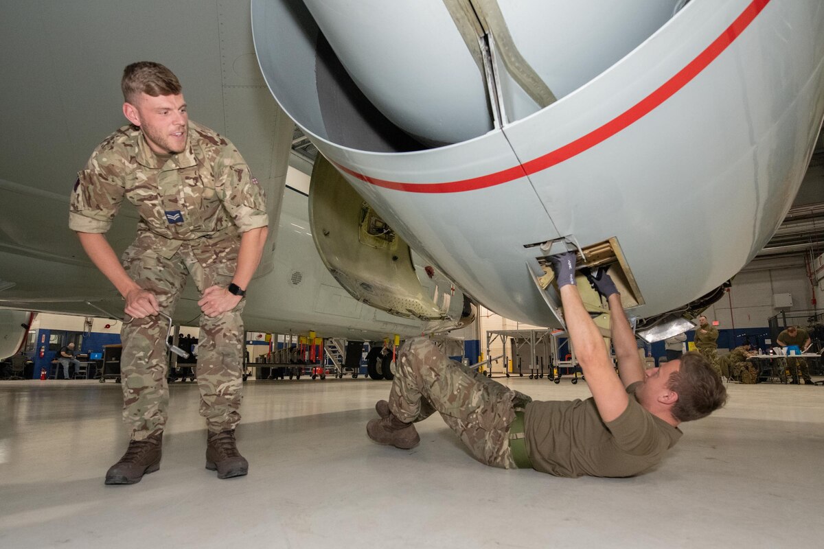 Two men work on an aircraft