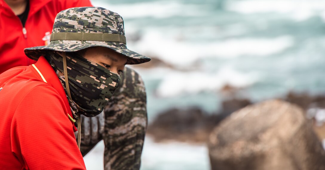 A Republic of Korea Marine scans the shoreline for debris during a beach cleanup at Homigot Square, South Korea, on March 24, 2023. To help combat pollution, U.S. Marines, ROK Marines and Sailors, and local organizations across South Korea came together to clean the beach to promote friendship and work together towards a common goal. (U.S. Marine Corps photo by Lance Cpl. Jonathan Beauchamp)
