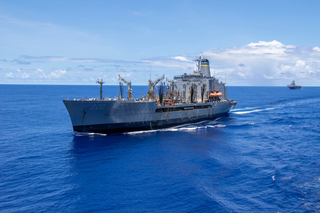 A ship steams through the water with another ship in the background.