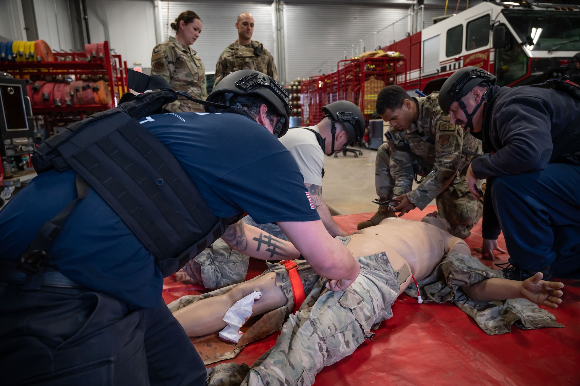 Members of the Connecticut National Guard Fire and Emergency Services, alongside 103rd Medical and Security Forces Squadrons perform Tactical Combat Casualty Care on a high fidelity training manikin at Bradley Air National Guard Base, East Granby, Connecticut, March 8, 2023. TCCC is the fundamentals of life-saving techniques developed for service members to provide trauma care in all situations.(U.S. Air National Guard photo by Master Sgt. Tamara Dabney)