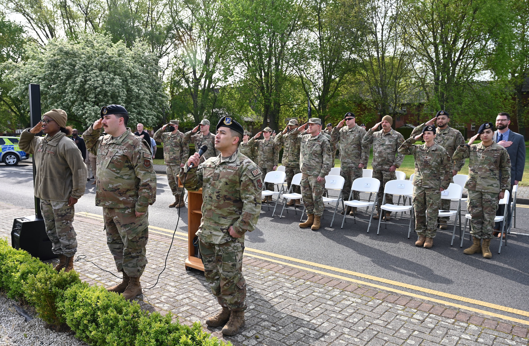 U.S. Air Force Staff Sgt. Lawrence Fernan, front right, 100th Security Forces Squadron Defender, sings the American National Anthem during the opening ceremony of Police Week May 15, 2023, at Royal Air Force Mildenhall, England. Police Week is held every year in May and this year is May 15 to 19. This year’s events include a ruck march, Defenders’ Challenge, “jail and bail,” and Fallen Defender memorial. (U.S. Air Force photo by Karen Abeyasekere)