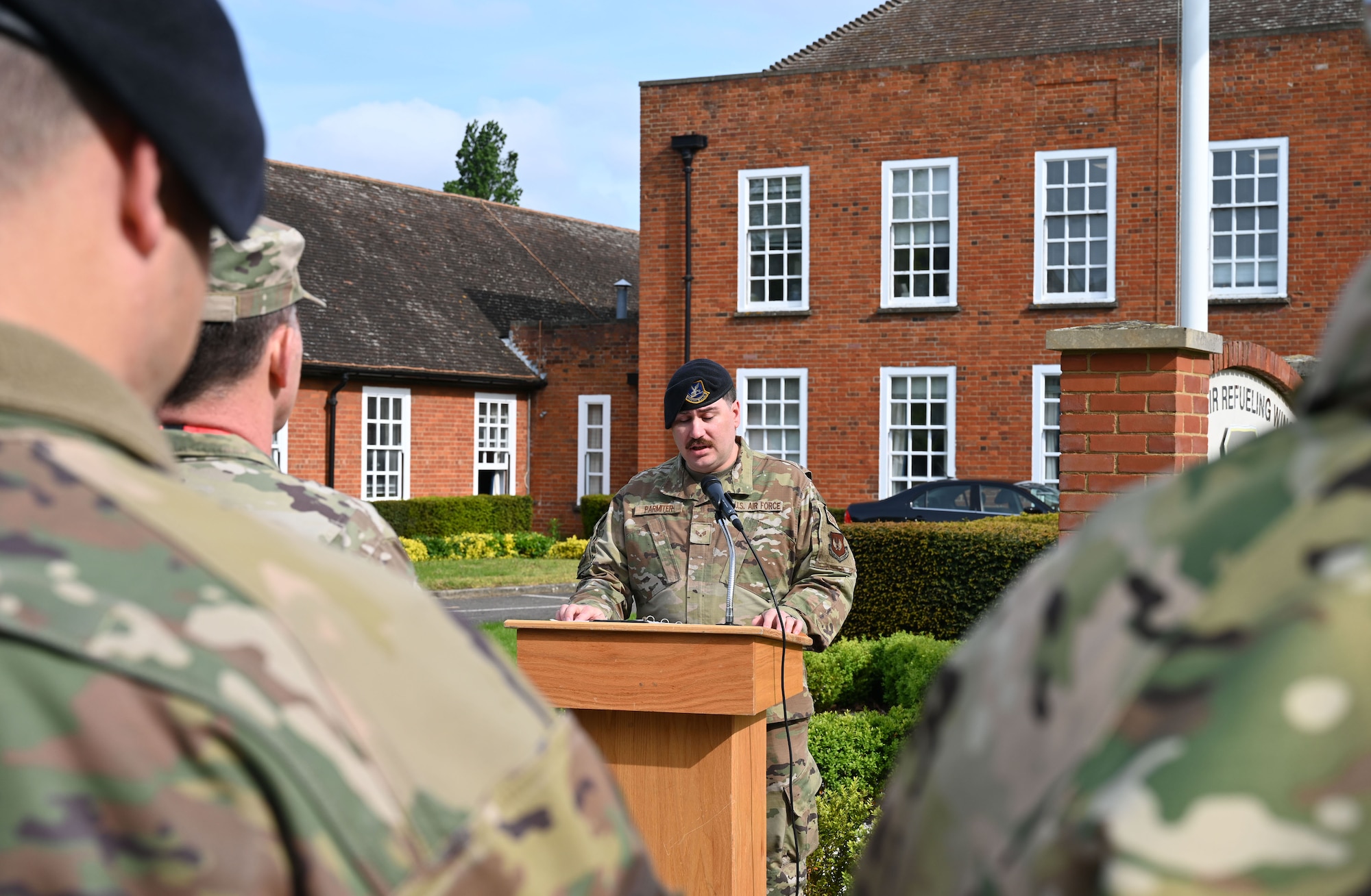U.S. Air Force Senior Airman David Parmiter, center, 100th Security Forces Squadron armory assistant NCO in charge, speaks as Master of Ceremonies during the opening ceremony of Police Week May 15, 2023, at Royal Air Force Mildenhall, England. Police Week is held every year in May and this year is May 15 to 19. This year’s events include a ruck march, Defenders’ Challenge, “jail and bail,” and Fallen Defender memorial. (U.S. Air Force photo by Karen Abeyasekere)