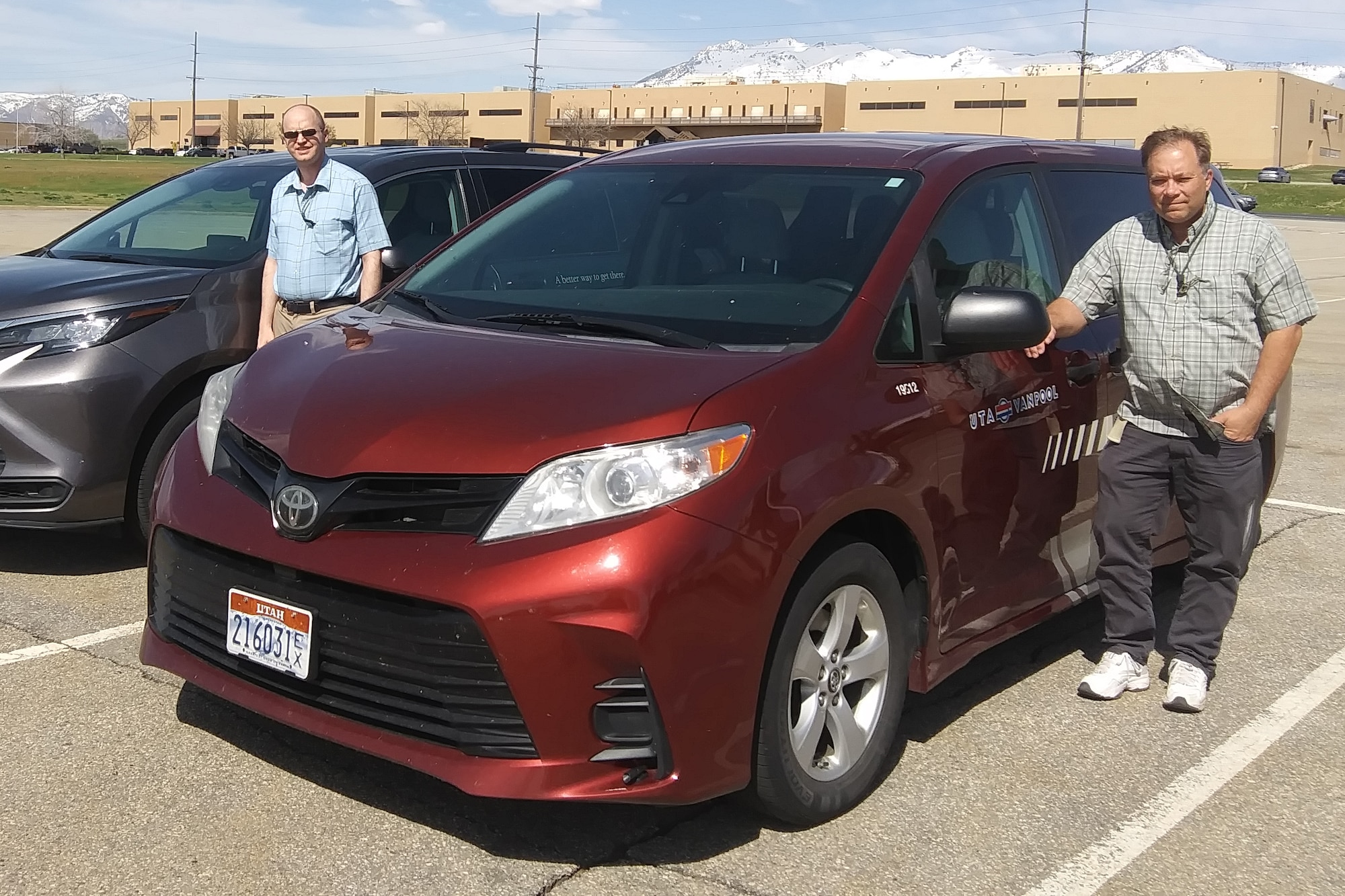 two men standing by a van in a parking lot