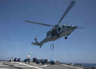 Sailors aboard the guided-missile destroyer USS Arleigh Burke (DDG 51) conduct in-flight refueling training with an MH-60S Sea Hawk helicopter.
