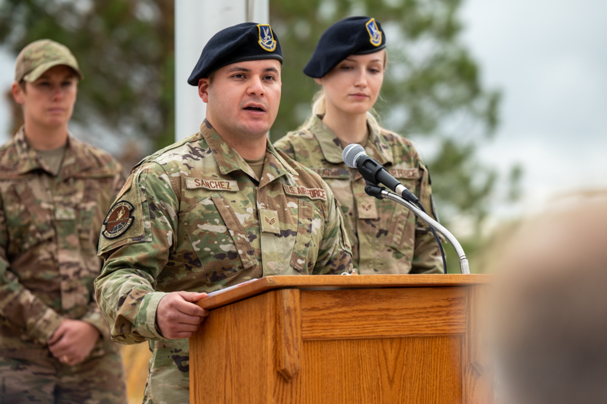 Members of a security forces squadron talk in front of a podium.