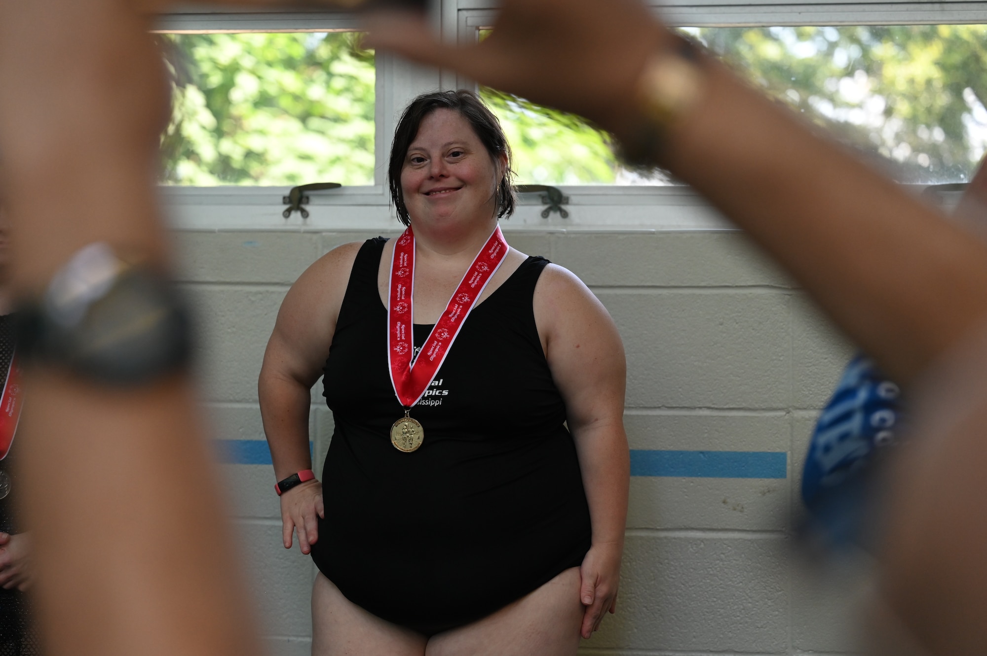 A Special Olympics Mississippi athlete poses with her swimming medal during the SOMS Summer Games at Keesler Air Force Base, Mississippi, May 13, 2023.