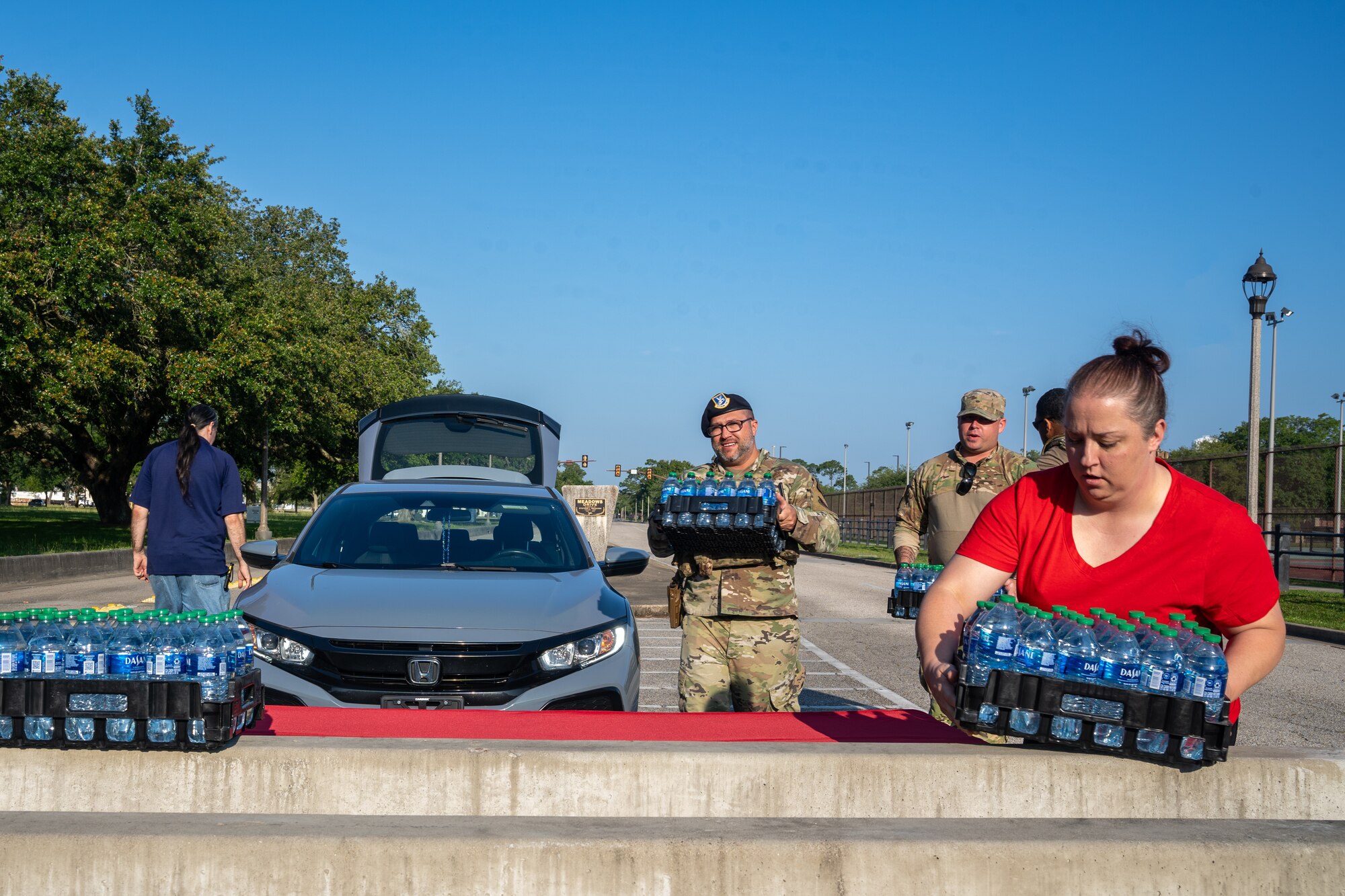 Stephanie Wainscott, Army & Air Force Exchange Services stockroom manager, sets up a water station with Airmen from the 81st Security Forces Squadron before the National Police Week 5K Memorial Ruck at Keesler Air Force Base, Mississippi, May 16, 2023.