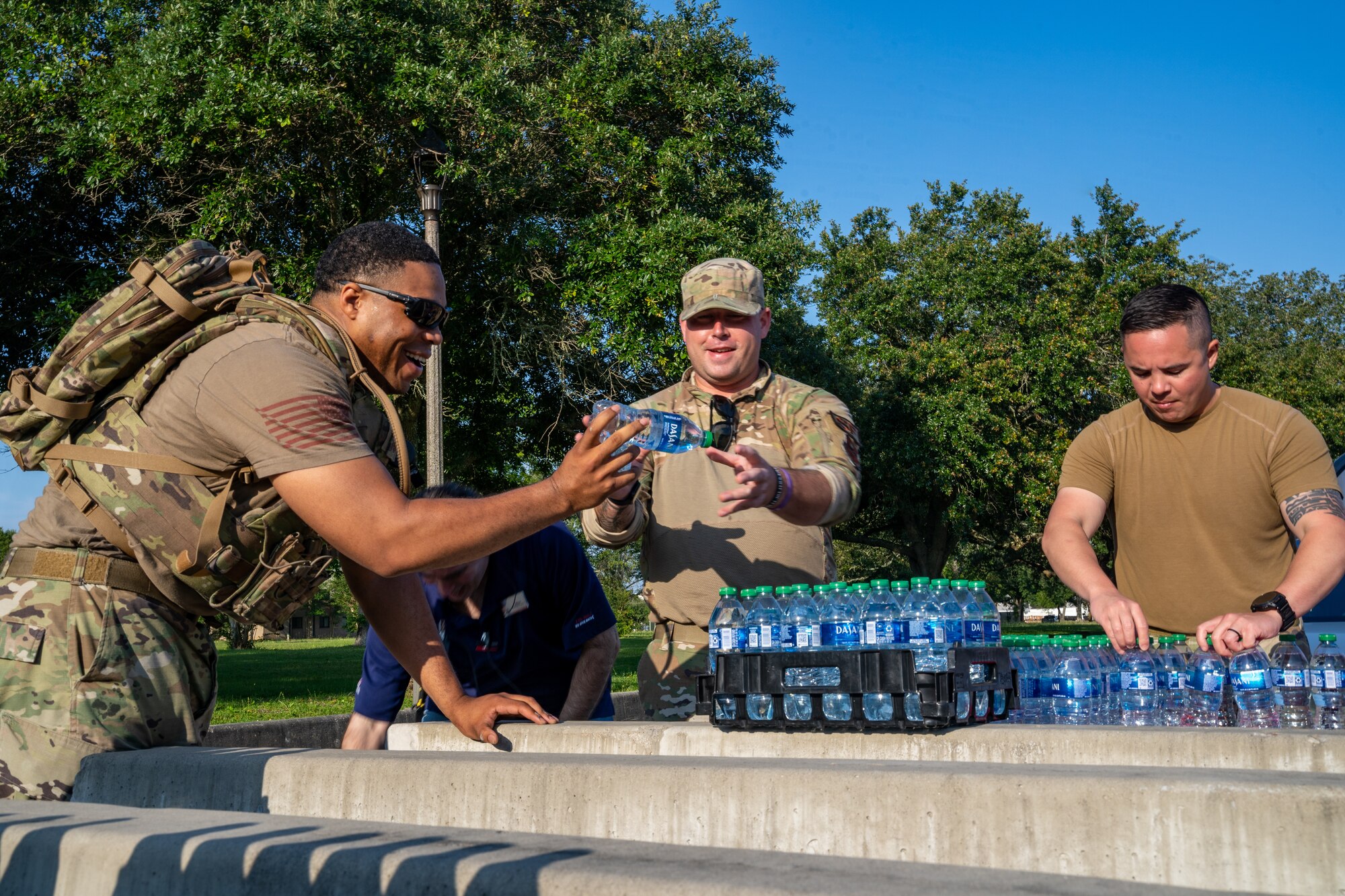 U.S. Air Force Master Sgt. Perry Sinclair, 81st Security Forces Squadron flight chief, Master Sgt. Jason Gobo, 81st SFS plans and programs superintendent, and Tech. Sgt. Max Biser, 81st SFS commander support staff NCO in charge, set up a water station before the National Police Week 5K Memorial Ruck at Keesler Air Force Base, Mississippi, May 16, 2023.