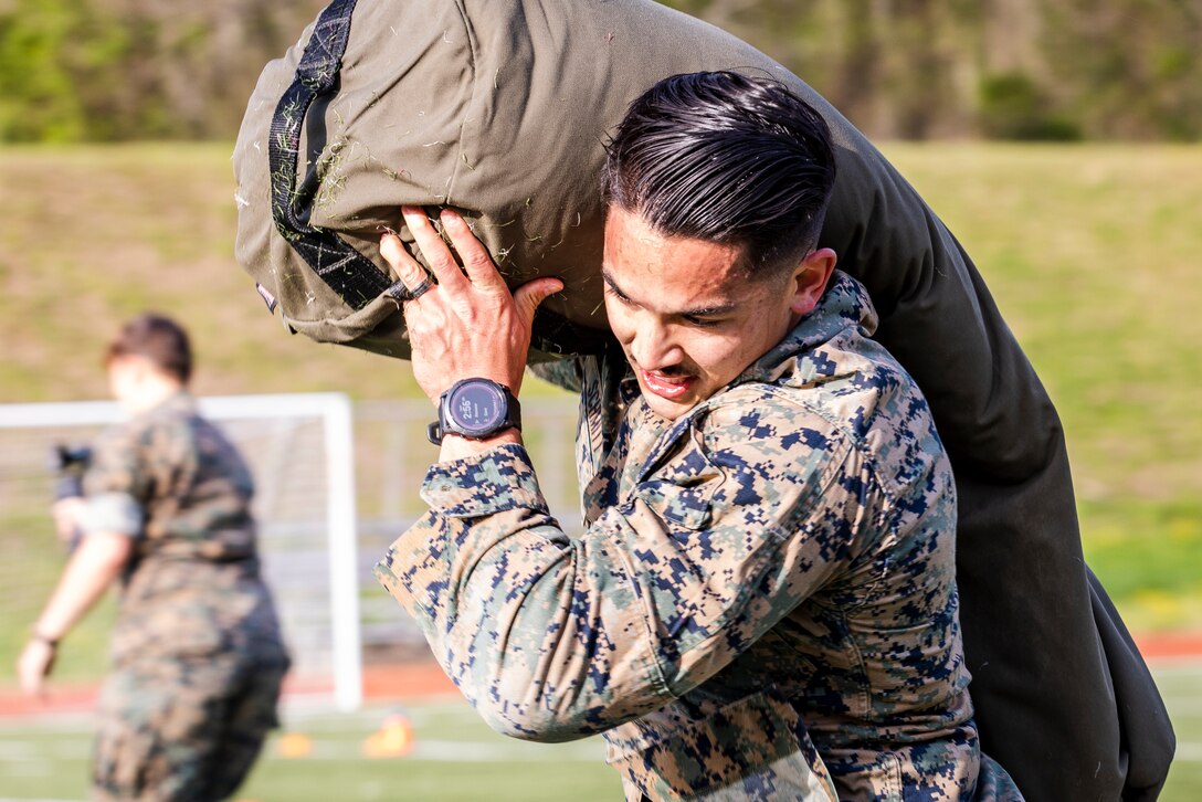 U.S. Marine Corps Staff Sgt. John E. Schmitt, senior non-commission officer in charge, School of Infantry East, Camp Gieger, Noth Carolina, carries a 150-pound sandbag as part of the “Gas Can” event during the first Training Education Command Fittest Instructor Competition on Marine Corps Base Quantico, Virginia, April 12, 2023. The “Gas Can” event is a non-stop combat fitness test designed to push even the fittest Marines to their limit.  (U.S. Marine Corps photo by James Frank)
