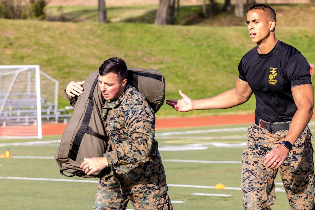 U.S. Marine Corps Staff Sgt. Michael R. Montesanto, an instructor with Marine Artillery Detachment, Fort Sill, Oklahoma, carries a 150-pound sandbag as part of the “Gas Can” event during the first Training Education Command Fittest Instructor Competition on Marine Corps Base Quantico, Virginia, April 12, 2023. The “Gas Can” event is a non-stop combat fitness test designed to push even the fittest Marines to their limit.  (U.S. Marine Corps photo by James Frank)