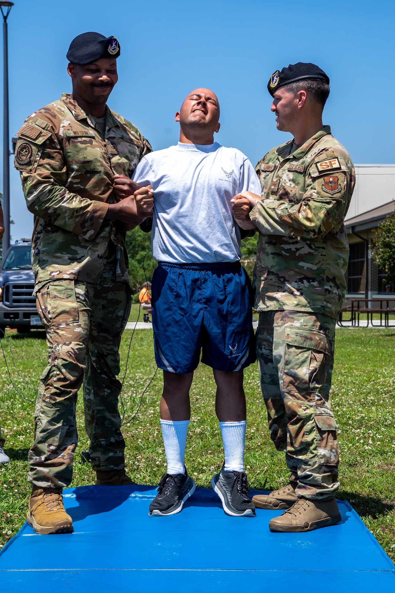 U.S. Air Force Airman 1st Class José Valce Gonzalez, 81st Security Forces Squadron defender, gets tased by Staff Sgt. Jeffrey Wilson, 81st SFS flight sergeant, and Staff Sgt. John James, 81st SFS defender, during a demonstration for National Police Week at Keesler Air Force Base, Mississippi, May 16, 2023.
