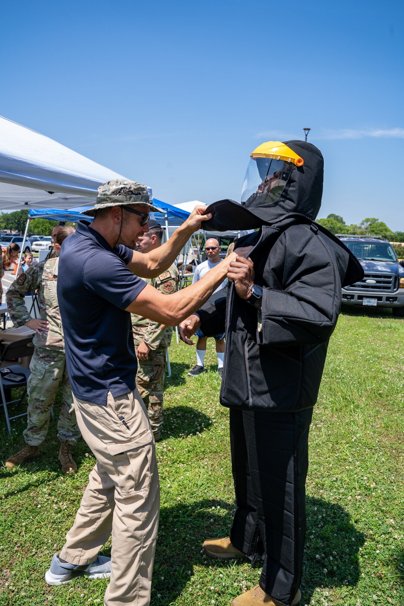 Justin Depew, 81st Security Forces Squadron training instructor, adjusts a taser simulation training suit for U.S. Air Force Staff Sgt. Jeffrey Wilson, 81st SFS flight sergeant, during a demonstration for National Police Week at Keesler Air Force Base, Mississippi, May 16, 2023.