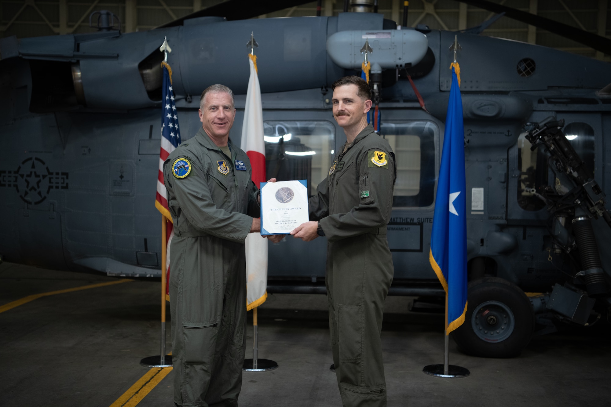 Two men pose with an award.