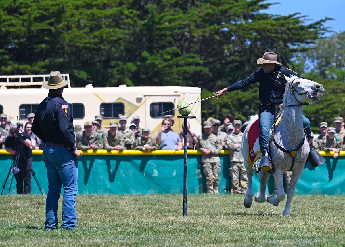A member of the 11th Armored Cavalry Regiment horse detachment slices a watermelon during a demonstration at Language Day at the Defense Language Institute Foreign Language Center Calif., May 12, 2023. The members demonstrated proficiency and coordination as a group and individuals. (U.S. Air Force photo by Airman 1st Class Zach Heimbuch)