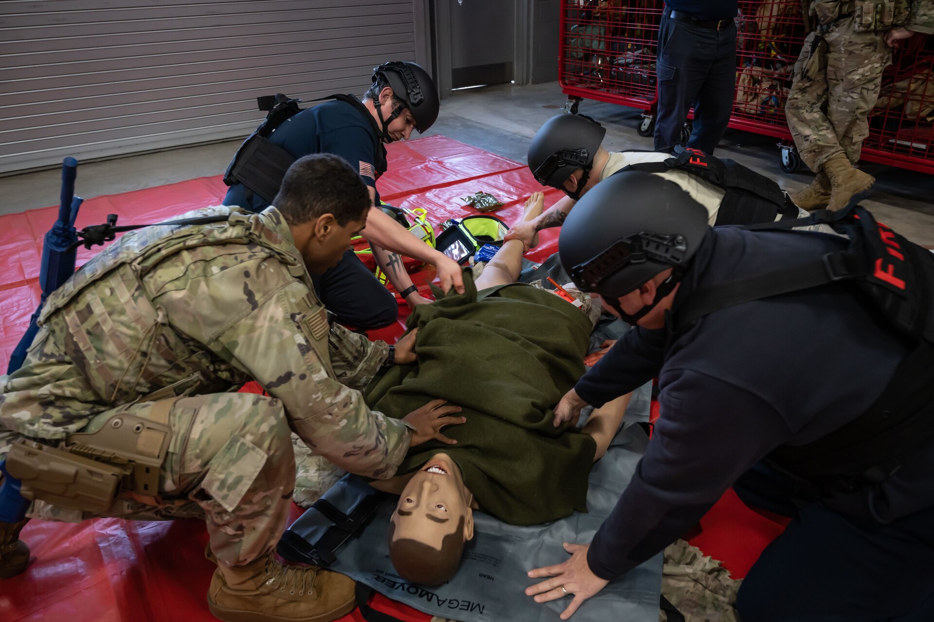 Members of the Connecticut National Guard Fire and Emergency Services, alongside 103rd Medical and Security Forces Squadrons perform Tactical Combat Casualty Care on a high fidelity training manikin at Bradley Air National Guard Base, East Granby, Connecticut, March 8, 2023. TCCC is the fundamentals of life-saving techniques developed for service members to provide trauma care in all situations.(U.S. Air National Guard photo by Master Sgt. Tamara Dabney)