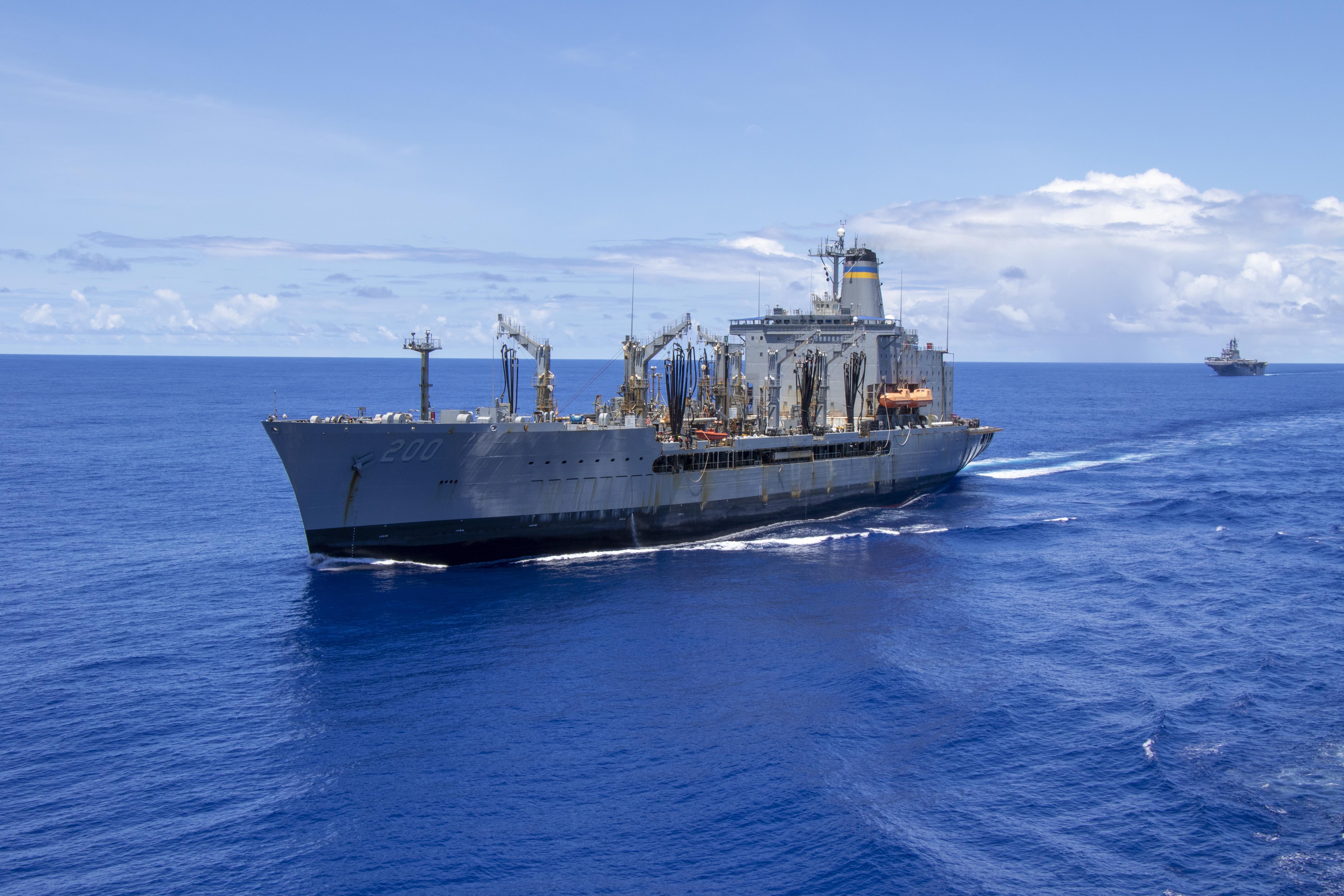 A ship steams through the water with another ship in the background.