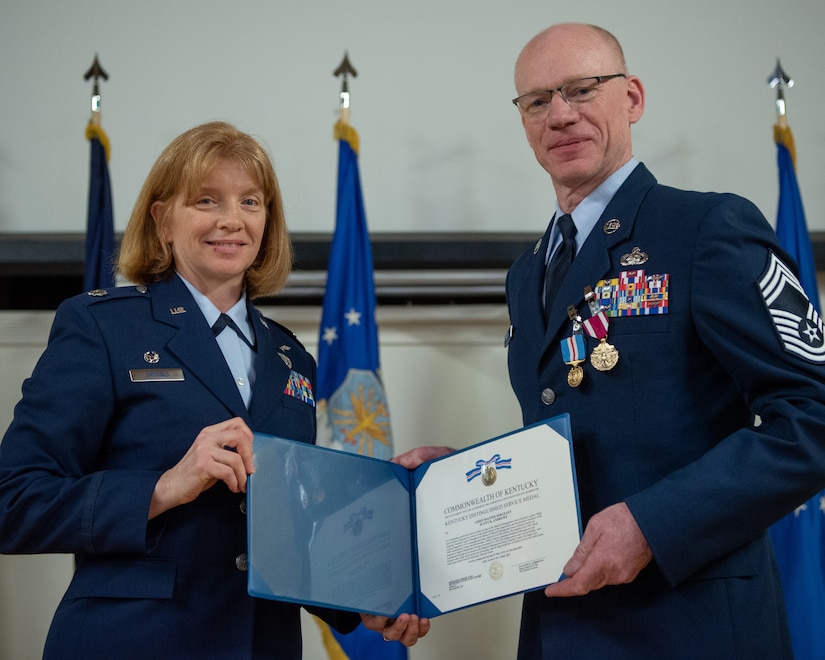 Chief Master Sgt. Scott Andrews, right, material management chief enlisted manager for the 123rd Logistics Readiness Squadron, receives the Kentucky Distinguished Service Medal from Lt. Col. Leslie Brooks, 123rd LRS commander, during Andrews’ retirement ceremony at the Kentucky Air National Guard Base in Louisville, Ky., April 29, 2023. Andrews is retiring after 35 years of military service. (U.S. Air National Guard photo by Tech. Sgt. Joshua Horton)