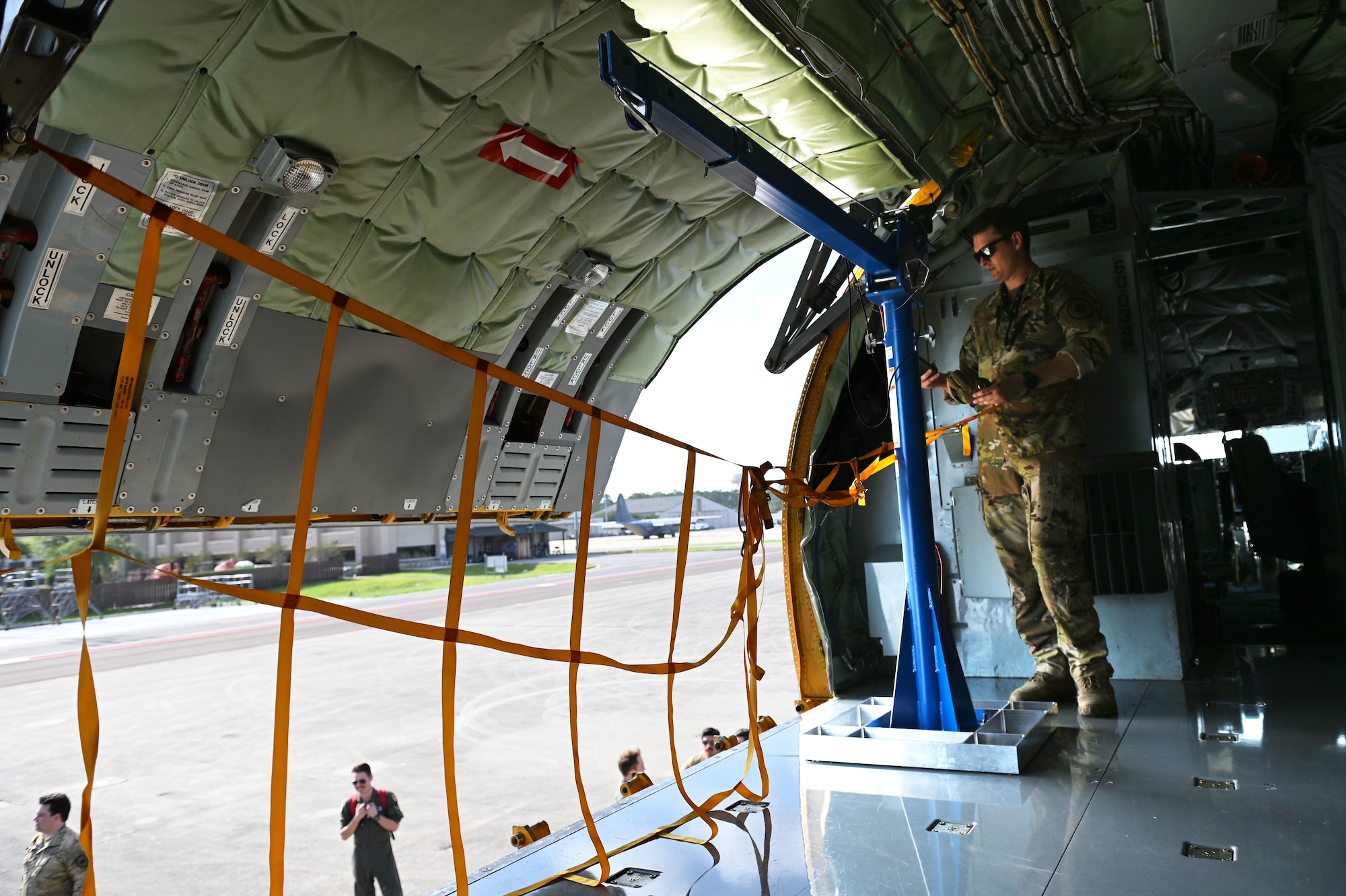 U.S. Air Force Tech. Sgt. Nicholas Sowder, 509th Weapons Squadron Advanced Instructor Training cadre and inflight refueling specialist, closes the cargo door of KC-135 Stratotanker next to the Pack and Transport Reloader crane (PATR) prototype at Hurlburt Field, Florida, May 6, 2023. Airmen from the 509th WPS tested a new prototype PATR crane during an integration training at a special operations forces exercise at Hurlburt Field. (U.S. Air Force photo by Staff Sgt. Lawrence Sena)