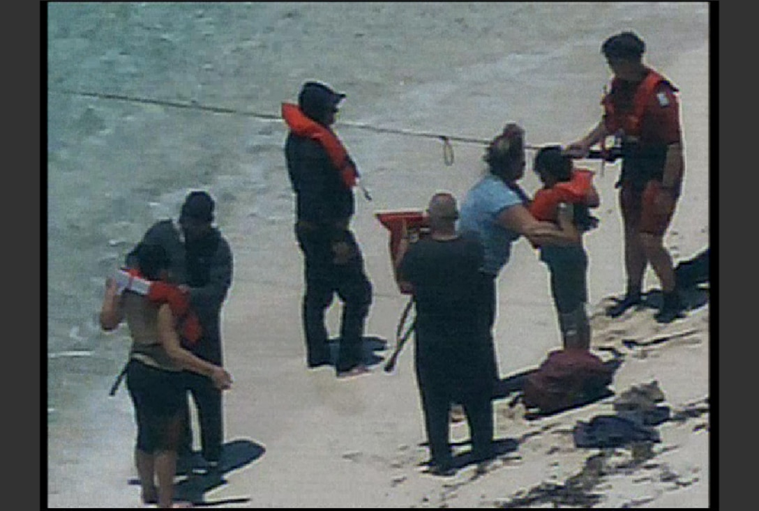 A Coast Guard Cutter Hamilton rescue swimmer arrives on shore of Cay Sal Island, Bahamas, May 9, 2023 to rescue six migrants from being stranded on the island. The migrants were safely transported to Coast Guard Cutter Hamilton. (U.S. Coast Guard courtesy photo)