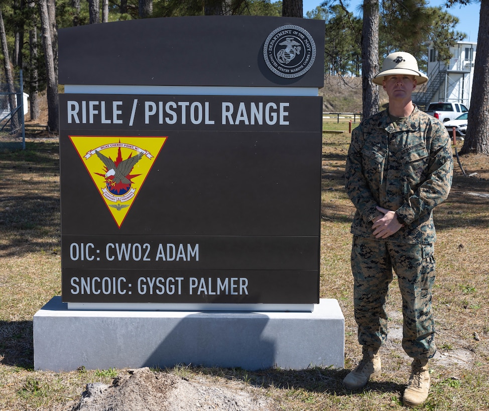 U.S. Marine Corps Gunnery Sgt. Garrett Palmer, staff noncommissioned officer in charge of Marine Corps Air Station (MCAS) Cherry Point rifle range poses for a photo in front the rifle range sign at MCAS Cherry Point, North Carolina, March 20, 2023. Palmer shows his leadership through respect and compassion and builds leaders for the future. (U.S. Marine Corps photo by Cpl. Jade Farrington)