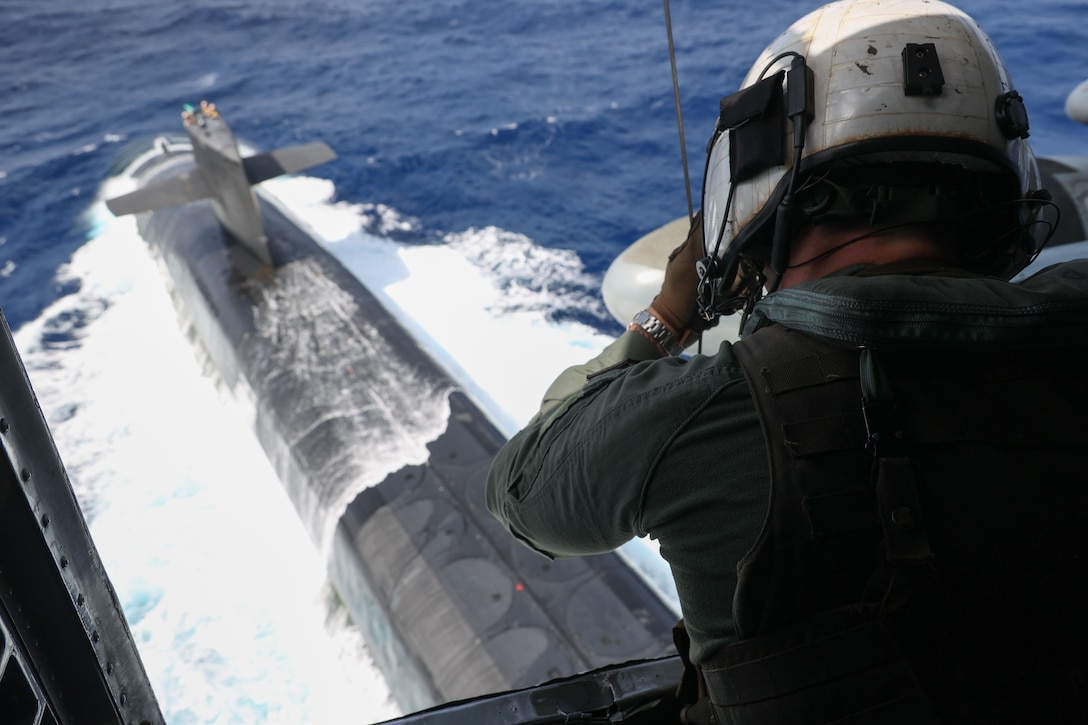 U.S. Marine Corps Staff Sgt. Joseph McDonnell, a crew chief with Marine Heavy Helicopter Squadron 462, 1st Marine Aircraft Wing, III Marine Expeditionary Force, lowers a package to the Ohio-class ballistic missile submarine USS Maine (SSBN 741) during a vertical replenishment in the Philippine Sea, May 9, 2023. Vertical replenishments enable naval vessels to quickly receive critical resources without disrupting maritime security operations while underway. III MEF is postured to enable naval expeditionary operations within the first island chain as part of a Stand-in-Force.
