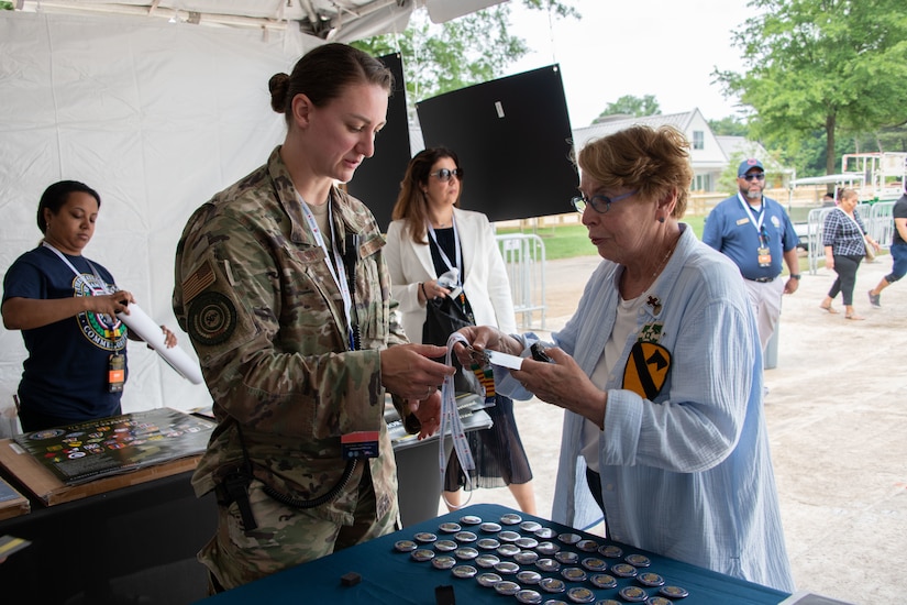 Maj. Jenifer Stretch, Air Force deputy of operations for the Vietnam Commemoration, gives Vietnam veterans memorabilia in celebration of the Vietnam “Welcome Home” Ceremony at the National Mall in Washington D.C., May 13, 2023. (U.S. Air Force photo by Senior Airman Daekwon Stith)