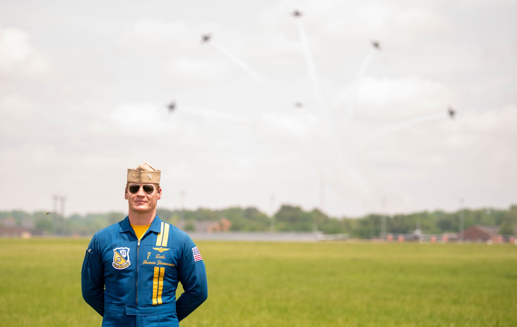 Pilot stands in front of formation of planes.
