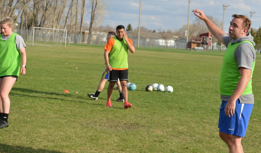 U.S. Air Force Capt. Micheal Thrasher, 5th Security Forces Squadron director of operations and Air Force Soccer Club coach, talks with his team during soccer practice at the Sertoma Sports Complex, Minot, North Dakota, May 10, 2023.  Thrasher had the club run soccer drills to improve their ability to work as a team. (U.S. Air Force photo by Airman 1st Class Trust Tate)
