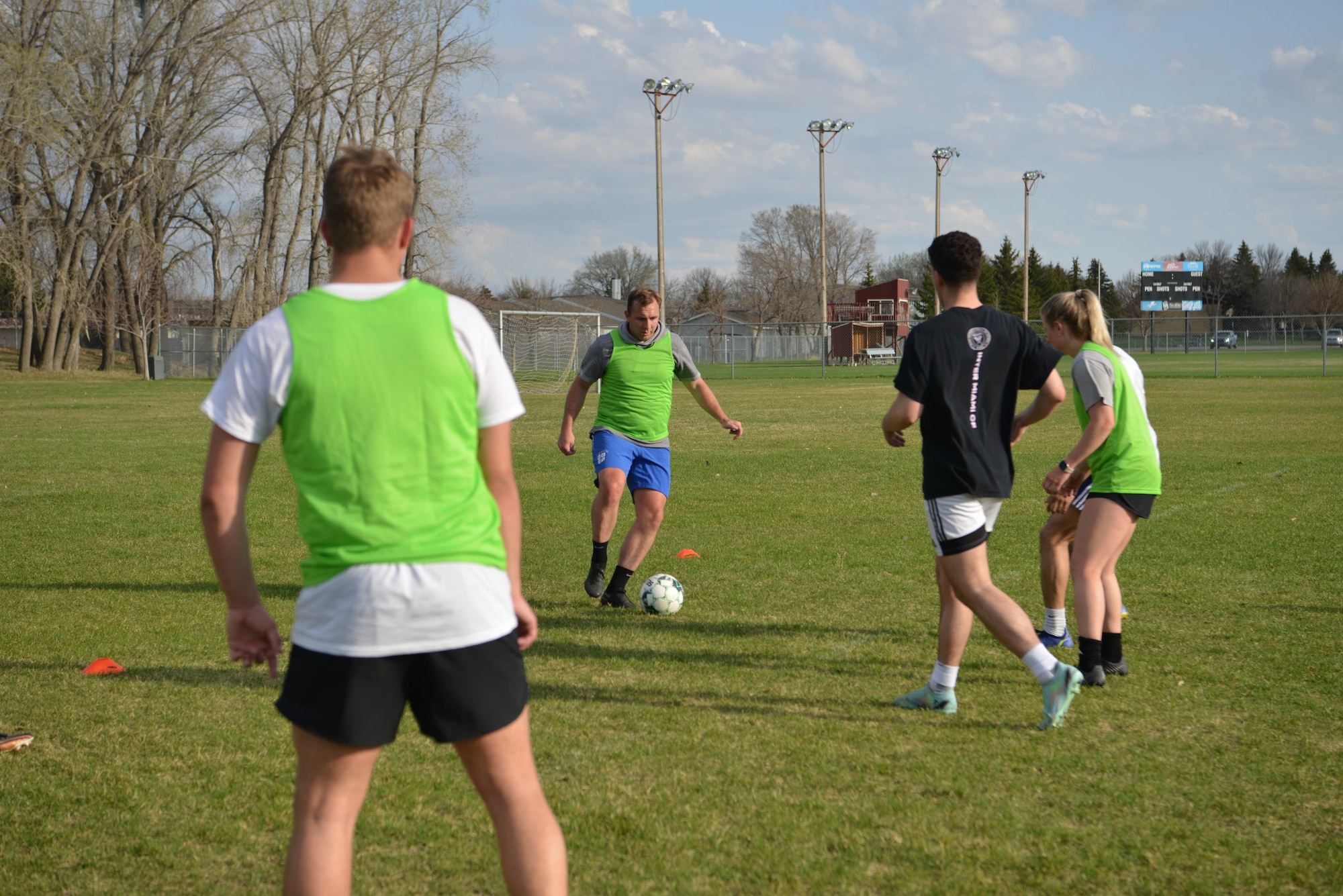 U.S. Air Force Capt. Michael Thrasher, 5th Security Forces Squadron director of operations and Air Force Soccer Club coach, kicks a soccer ball to a teammate at the Sertoma Sports Complex, Minot, North Dakota, May 10, 2023. Thrasher was running a soccer exercise with his team in order to sharpen their skills. (U.S. Air Force photo by Airman 1st Class Trust Tate)