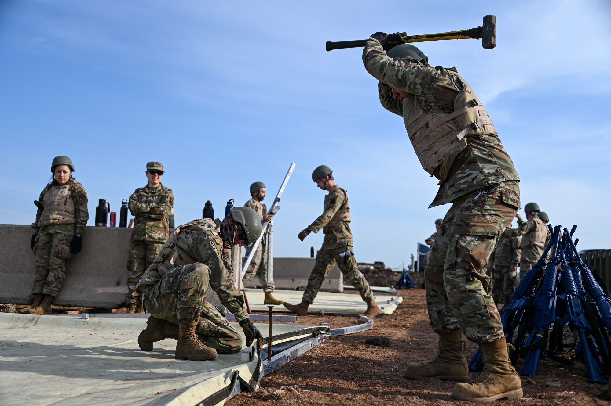 U.S. Air Force Senior Airman Sergio Rodriguez, 97th Civil Engineering Squadron (CES) electrical systems apprentice, uses a sledgehammer to hit a stake at Altus Air Force Base, Oklahoma, May 10, 2023. Airmen from the 97th CES participated in a deployment training that taught them how-to put-up tents in various ways.  (U.S. Air Force photo by Senior Airman Kayla Christenson)
