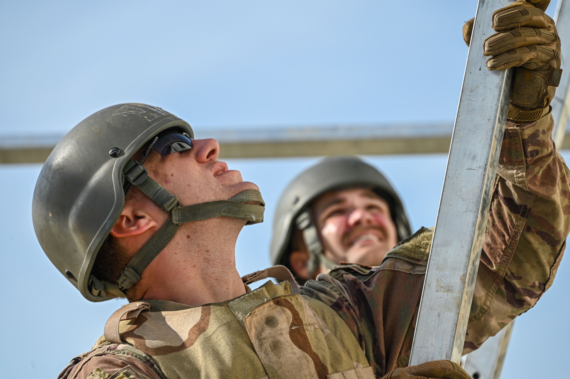 U.S. Air Force Staff Sgt. Edward Baron, 97th Civil Engineering Squadron power production technician, holds a piece of metal frame while building a tent at Altus Air Force Base, Oklahoma, May 10, 2023. Large tents are nailed down with stakes and help up with a mental framed structure. (U.S. Air Force photo by Senior Airman Kayla Christenson)