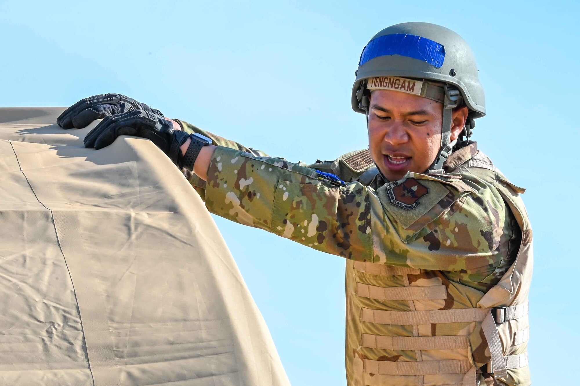 U.S. Air Force Senior Airman Adisorn Tiengngam, 97th Civil Engineer Squadron (CES) engineer apprentice, holds a tent during a deployment exercise at Altus Air Force Base, Oklahoma, May 10, 2023. During the deployment exercise 97th CES Airmen learned various deployment tasks from seasoned Airmen and weapon training from 97th Security Forces Squadron combat arms training and maintenance Airmen. (U.S. Air Force photo by Airman 1st Class Kari Degraffenreed)