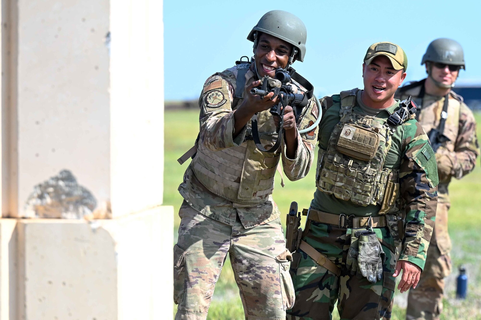 U.S. Air Force Master Sgt. James Ta, 97th Security Forces Squadron section chief of training and standardization, teaches Staff Sgt. Marquis Brown, 97th Civil Engineer Squadron power production technician, to hide behind barriers at Altus Air Force Base, Oklahoma, May 10, 2023. Different positions are held while training with the M4 rifle. (U.S. Air Force photo by Airman 1st Class Kari Degraffenreed)