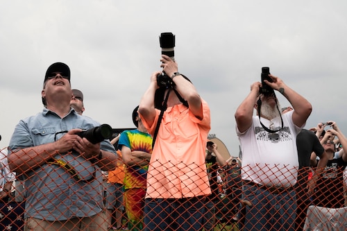 People with cameras look at sky