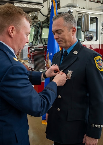 Maj. Nathan Thomsen pins a medal on Firefighter/Paramedic Jared Spaeth.