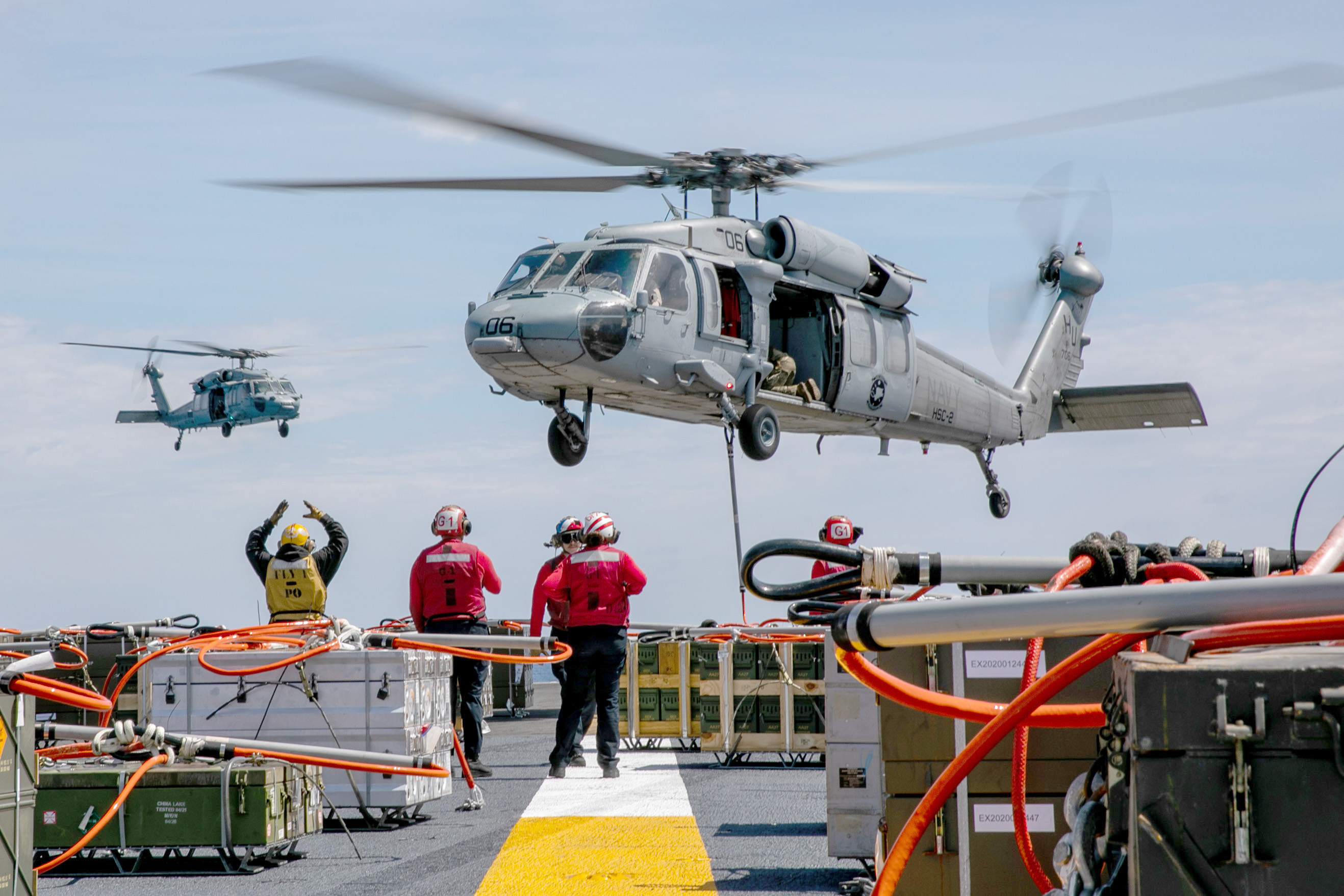 An MH-60S Sea Hawk helicopter attached to Helicopter Sea Combat Squadron (HSC) 2 retrieves ordnance from the flight deck of the Nimitz-class aircraft carrier USS George H.W. Bush (CVN 77) during an ordnance offload with the fast combat support ship USNS Supply (T-AOE 6).