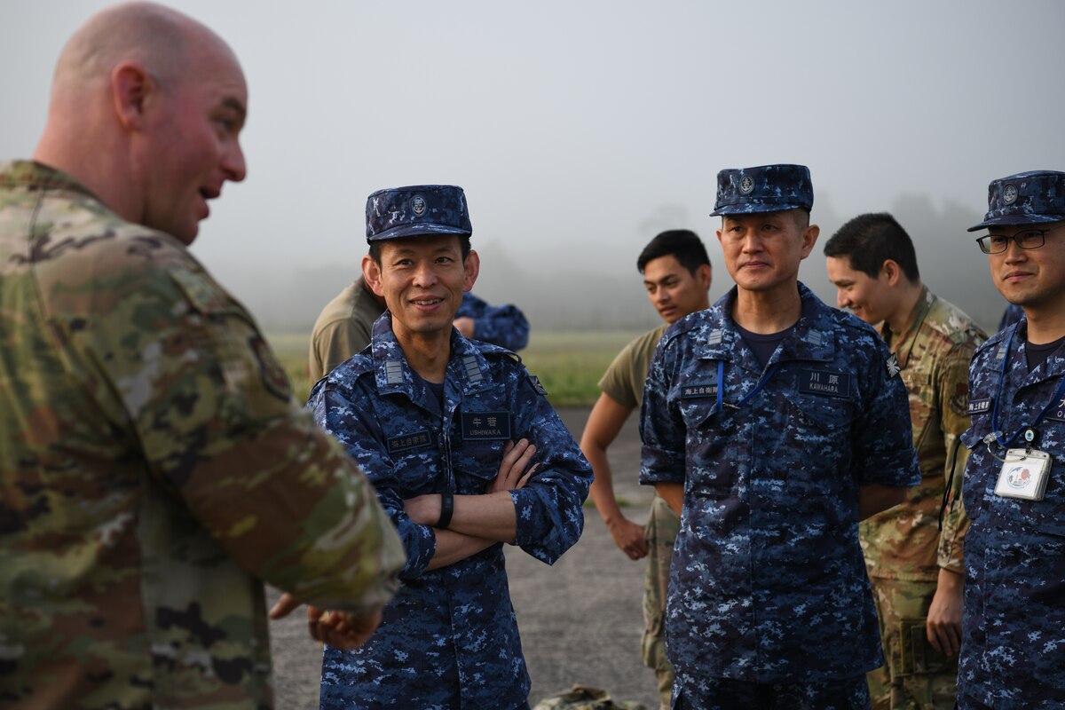 Members of the Japan Maritime Self-Defense Force listen to U.S. Air Force Master Sgt. Brent Fallon, Fifth Air Force readiness branch superintendent, as he gives instructions on how to complete a spall repair at Kanoya Air Base, Japan, May 15, 2023. Spall repairs are an efficient way to keep airfields serviceable by removing and replacing damaged parts of concrete slabs. (U.S. Air Force photo by Staff Sgt. Spencer Tobler)